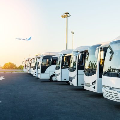 Buses at the parking lot of the airport at sunrise. Holiday, travel, tourism and vacation concept.